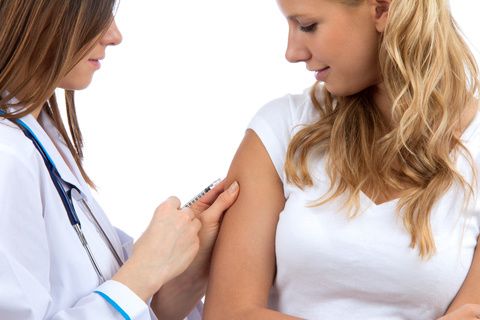 Healthcare professional administering a vaccine in a patient's upper arm
